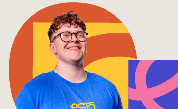A person with short curly hair and glasses smiles, wearing a blue shirt, standing in front of colourful geometric shapes.