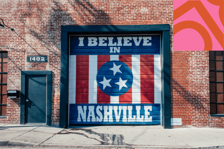 A garage door painted with the phrase "I Believe in Nashville" and the Tennessee flag design on a brick building with the number 1402.