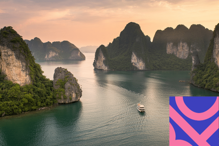 A boat sails through calm waters surrounded by rocky, green islands at sunset; a pink and blue geometric graphic is in the bottom right-hand corner.