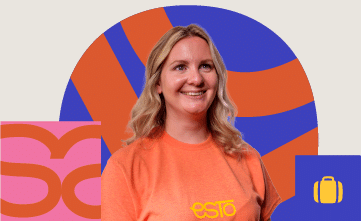 A smiling woman with blonde hair wearing an orange "esto" T-shirt stands in front of a colourful background with abstract shapes.