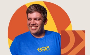 A man in a blue shirt with yellow "esto" text stands in front of a graphic background with orange and yellow geometric shapes.