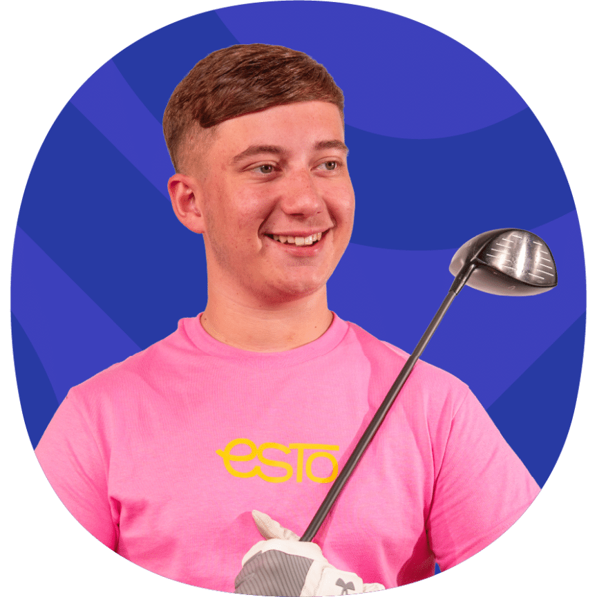 A person in a pink shirt holding a golf club smiles whilst looking to the side against a blue background.