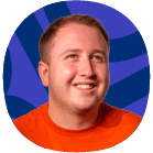 A smiling person with short light brown hair wearing an orange shirt, in front of a purple and blue abstract background.