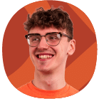 A young person with curly brown hair and glasses, wearing an orange shirt, smiling in front of an orange background with abstract shapes.