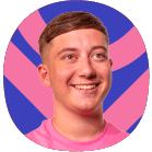 Smiling young man with short brown hair wearing a pink shirt, in front of a colourful blue and pink abstract background.