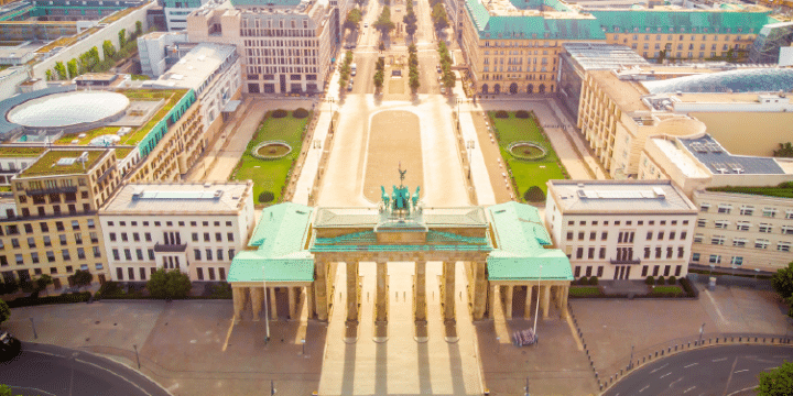 Aerial view of the Brandenburg Gate in Berlin, Germany, surrounded by historic buildings and wide streets on a clear day.