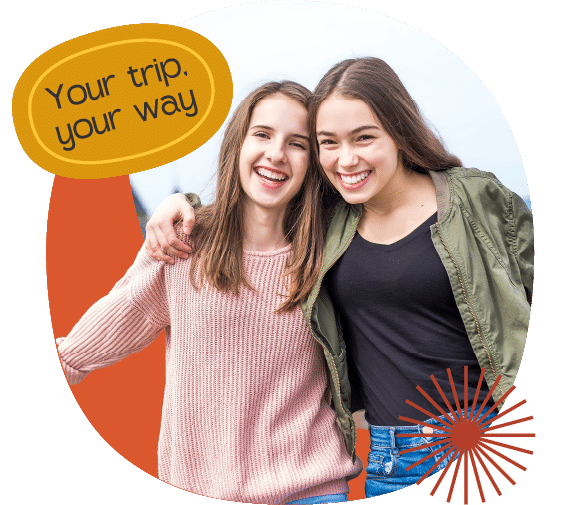 Two young women stand close together smiling at the camera. One has her arm round the other. Text bubble reads, "Your trip, your way.