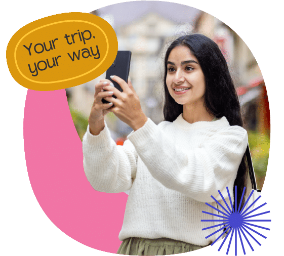A woman in a white jumper smiles whilst taking a selfie outside on her science trip in Iceland. Overlay text reads "Your trip. your way" on a yellow shape, with a blue starburst graphic at the bottom right.