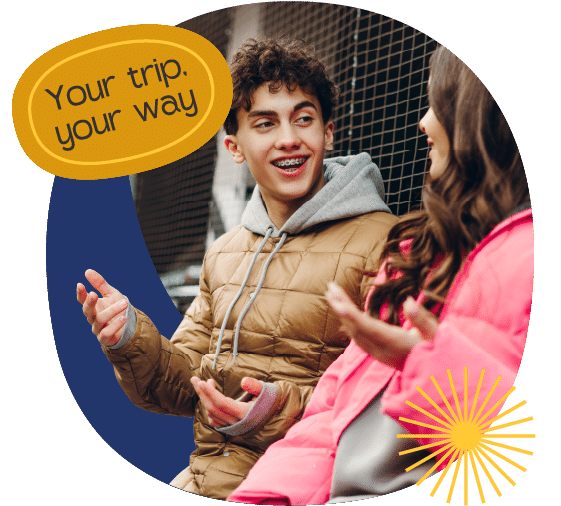 Two teenagers sit and talk outdoors, both wearing jackets. A yellow graphic reads "Your trip. your way" in the corner.