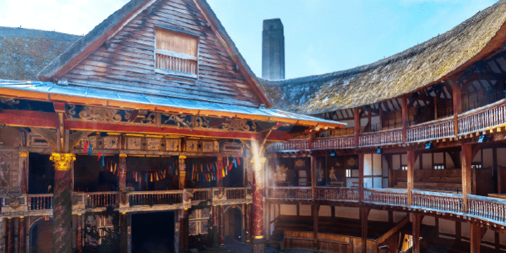 A wooden open-air theatre with a thatched roof, tiered seating, and a central stage, resembling the historic Globe Theatre in London.