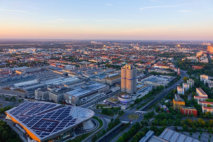 Aerial view of the BMW headquarters building in Munich, Germany, featuring the BMW logo and distinctive cylindrical towers.