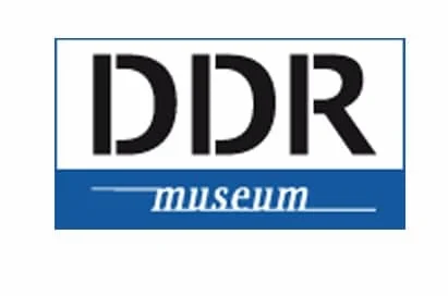 Logo of the DDR Museum with "DDR" in bold black letters above the word "museum" in white text on a blue background.