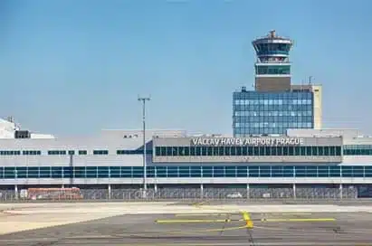 Václav Havel Airport Prague terminal building and control tower viewed from the runway on a clear day.