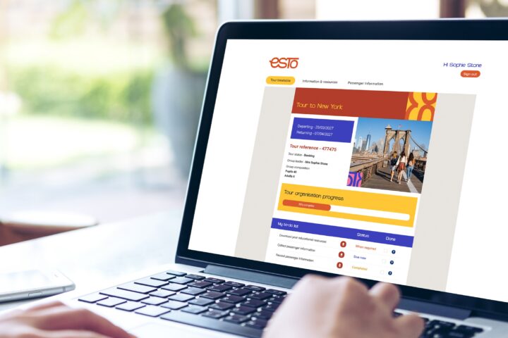 Person using a laptop displaying a travel booking website with details of a tour to New York, including departure information and a photo of the Brooklyn Bridge.