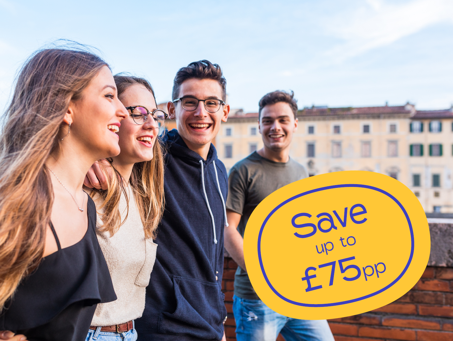 Four young adults smiling outdoors, walking arm in arm, with a sign in the foreground that reads, “Save up to £75pp”.
